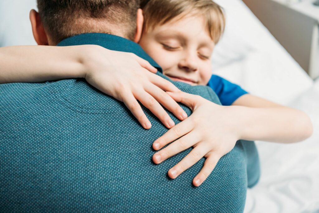 Pre-teen boy hugging father